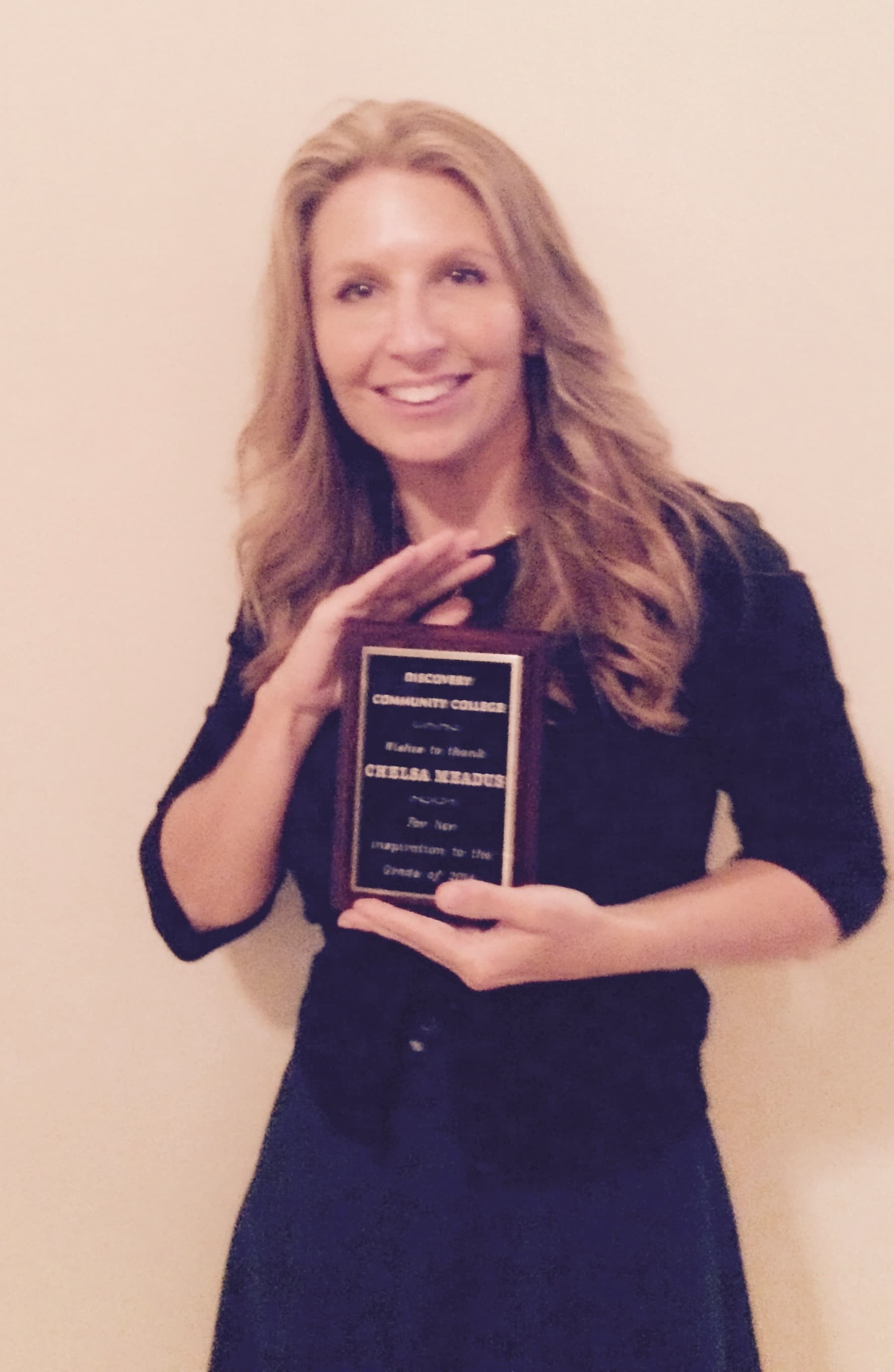 Chelsa Meadus holding the Discovery Community College award
